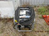un petit compresseur d'air posé par terre à côté d'un tas d'outils