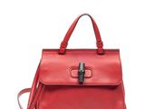 un sac à main en cuir rouge muni d'un fermoir métallique sur la poignée