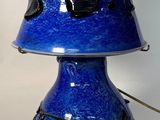 un vase bleu orné d'un motif rose et noir