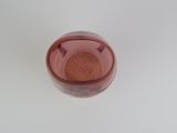 a pink glass with a small amount of liquid in it