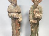 deux statues en bois représentant deux hommes portant un chapeau et une barbe