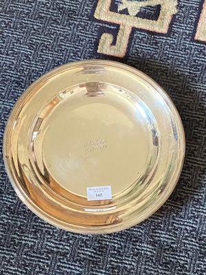 a gold plate sitting on a blue carpet next to a rug