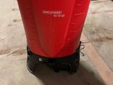 a red container with a black lid sitting on the floor