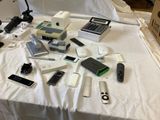 many electronic devices on a bed with a calculator and a calculator