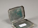 an old silver box with a tag on it sitting on a table