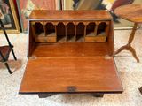 a small wooden desk with a drawer on top of it