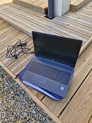 a laptop computer sitting on a wooden table on the ground