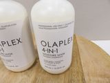 two bottles of olaplex 4 in 1 moisting mask on a cutting board