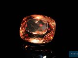 gros plan d'un diamant orange sur une surface noire