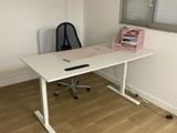 a white desk with a black chair in front of a window
