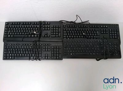 two keyboards sitting on top of each other on a table