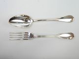 two spoons and a fork on a white table