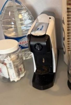 des bouteilles d'eau et un mixeur posés sur un plan de travail, à côté d'une bouteille d'eau
