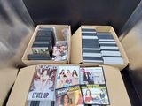 un grand nombre de dvd dans une boîte posée sur le sol