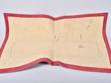 an open book with a red border on a white surface