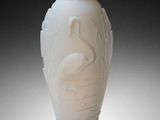a white vase sitting on a table with a black background