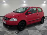 la voiture rouge est garée dans le garage sur le sol en damier