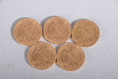 four gold coins sitting on top of each other on a white surface