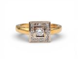 une bague en or jaune sertie d'un diamant de forme carrée entouré de petits diamants
