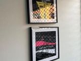two framed pictures hanging on the wall of a room