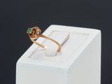 a close up of a gold ring with a green stone on it