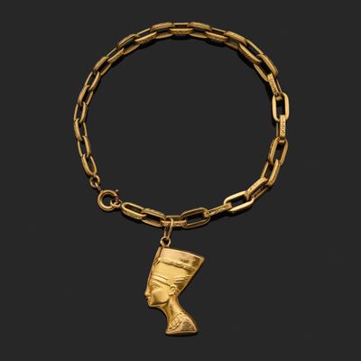 un bracelet en or orné d'un pendentif en forme de tête égyptienne