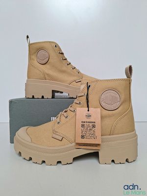 Les bottes sont de couleur beige et portent une étiquette.