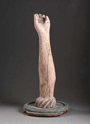 sculpture représentant une main posée sur une assiette, sur une surface grise