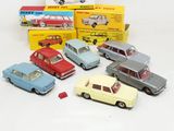 several toy cars are lined up in a row on a white surface