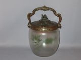 a glass jar with a gold lid on a white table