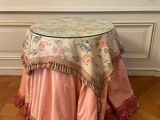 table with a pink table cloth on it sitting on top of a hard wood floor
