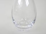 a clear glass vase with a small amount of water in it