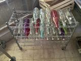 de nombreuses bouteilles vides posées sur un support métallique dans une cuisine