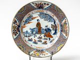 a blue and white plate with a picture of a man riding a horse