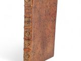 an old book sitting on top of a white surface