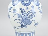 a blue and white vase with flowers on it