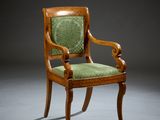 an antique wooden chair with green upholstered seat and arms