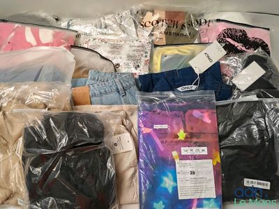 de nombreux sacs de vêtements entassés sur un lit