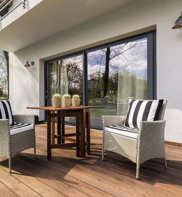 une terrasse avec deux chaises et une table