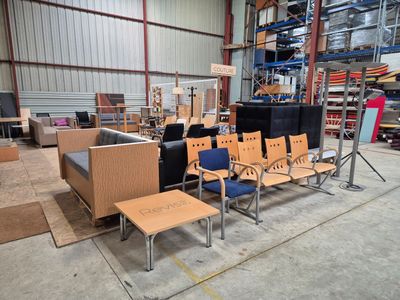 de nombreuses chaises et tables dans un vaste entrepôt
