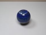 a blue marble ball sitting on a white surface