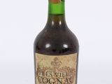 une vieille bouteille de vin posée sur une surface blanche