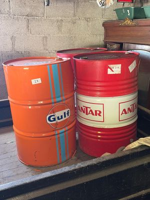 two red and one orange barrels sitting on a shelf
