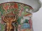 a vase that has a cow on it and a man in the background
