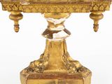 a gold clock on a stand on a white background