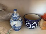 two blue and white vases on a shelf next to each other