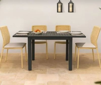 une table avec quatre chaises et un bol de fruits posé dessus