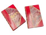 pair of red book covers with gold designs on them on a white surface