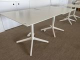 a white table with three chairs and a laptop on it