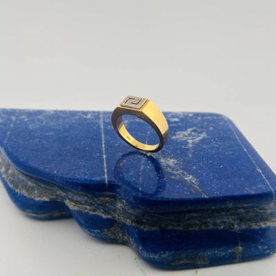 a close up of a gold ring on a blue stone